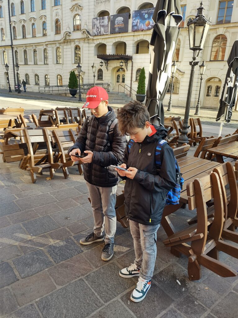 Schüler stehen mit Handys auf der Straße